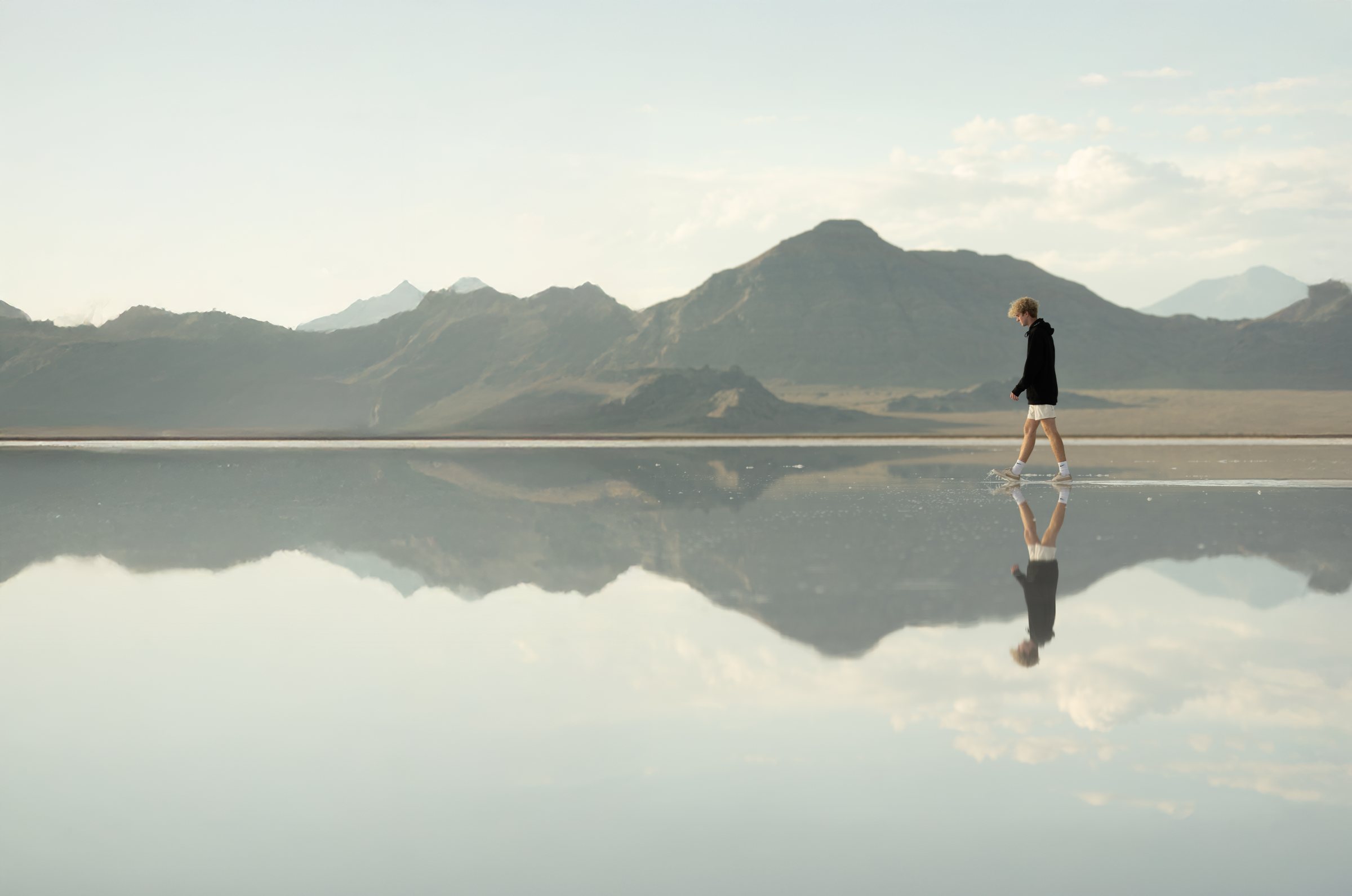 Blake McCann walking across a mirror-calm salt flat